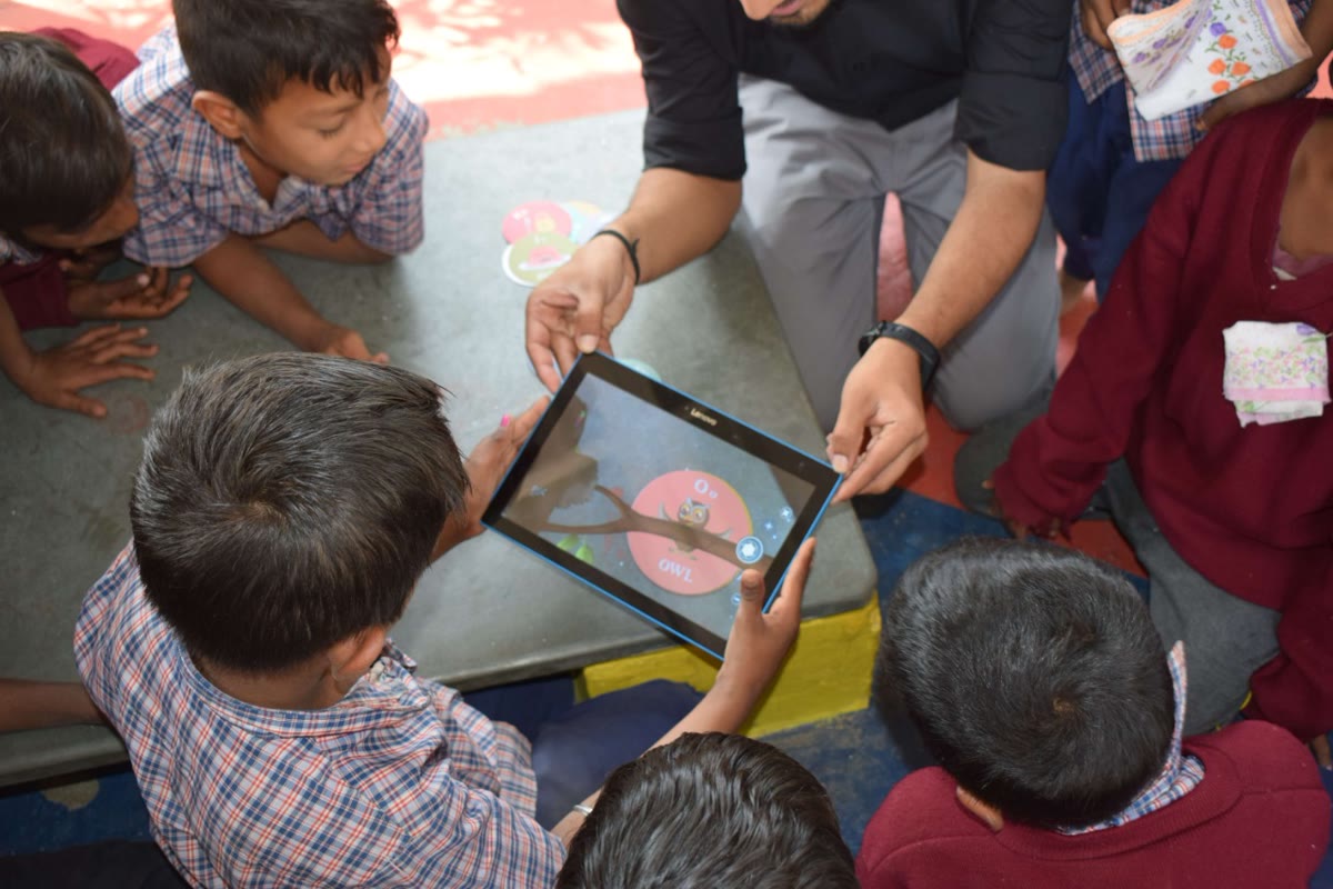 An AR owl character shown on a tablet while children watch