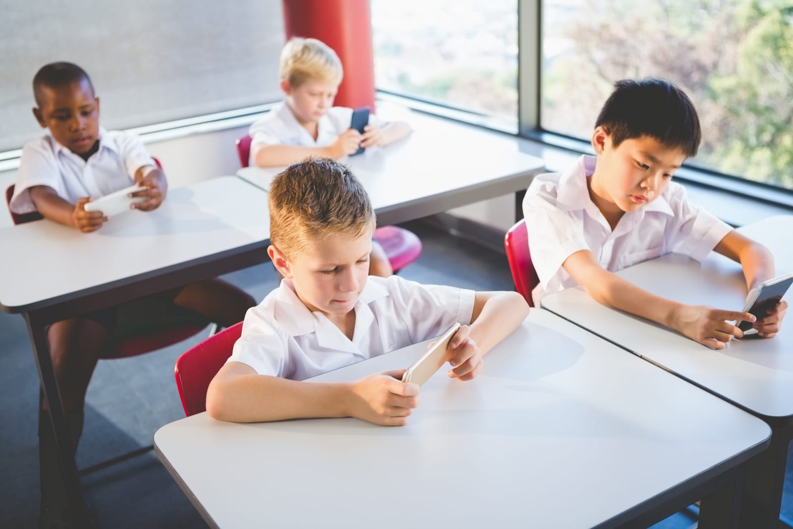 Students in a classroom using ARKidzoo on a mobile phone